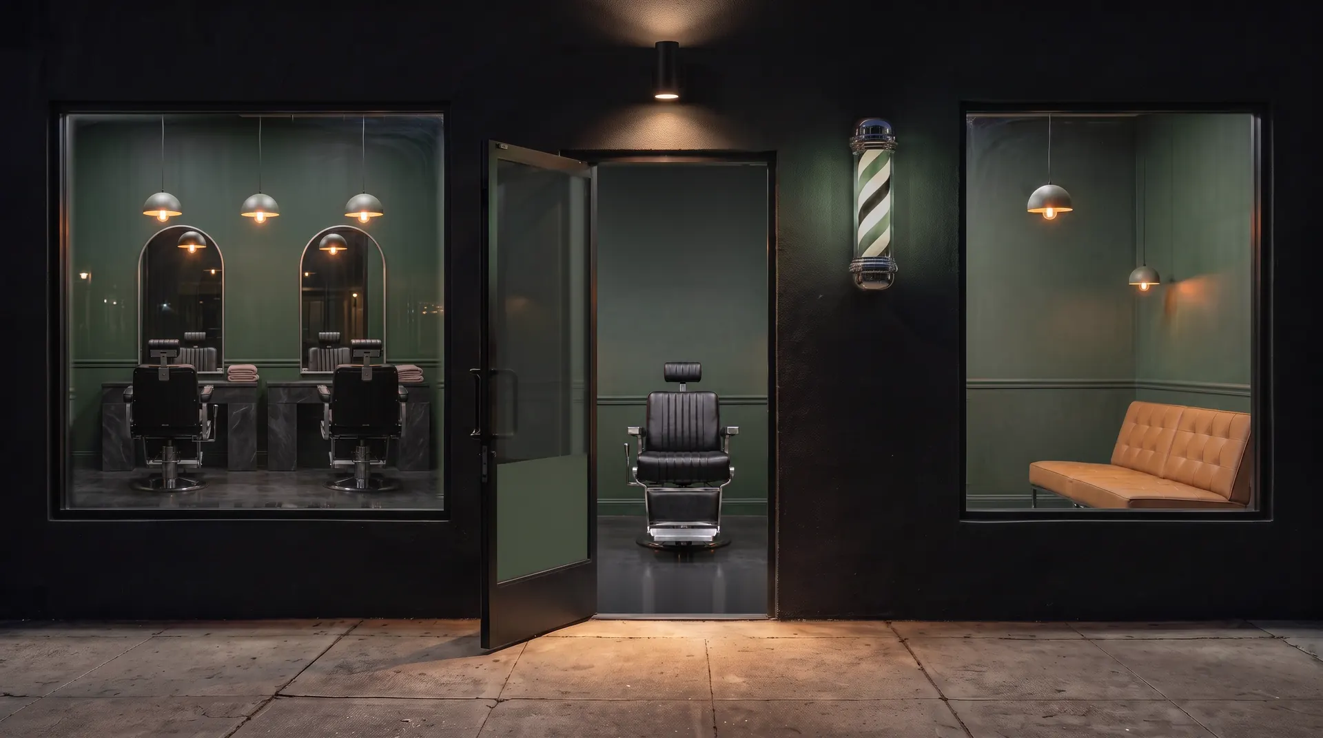 Barbershop storefront at night with a lit green and white barber pole, an open glass door and a black barber chair inside